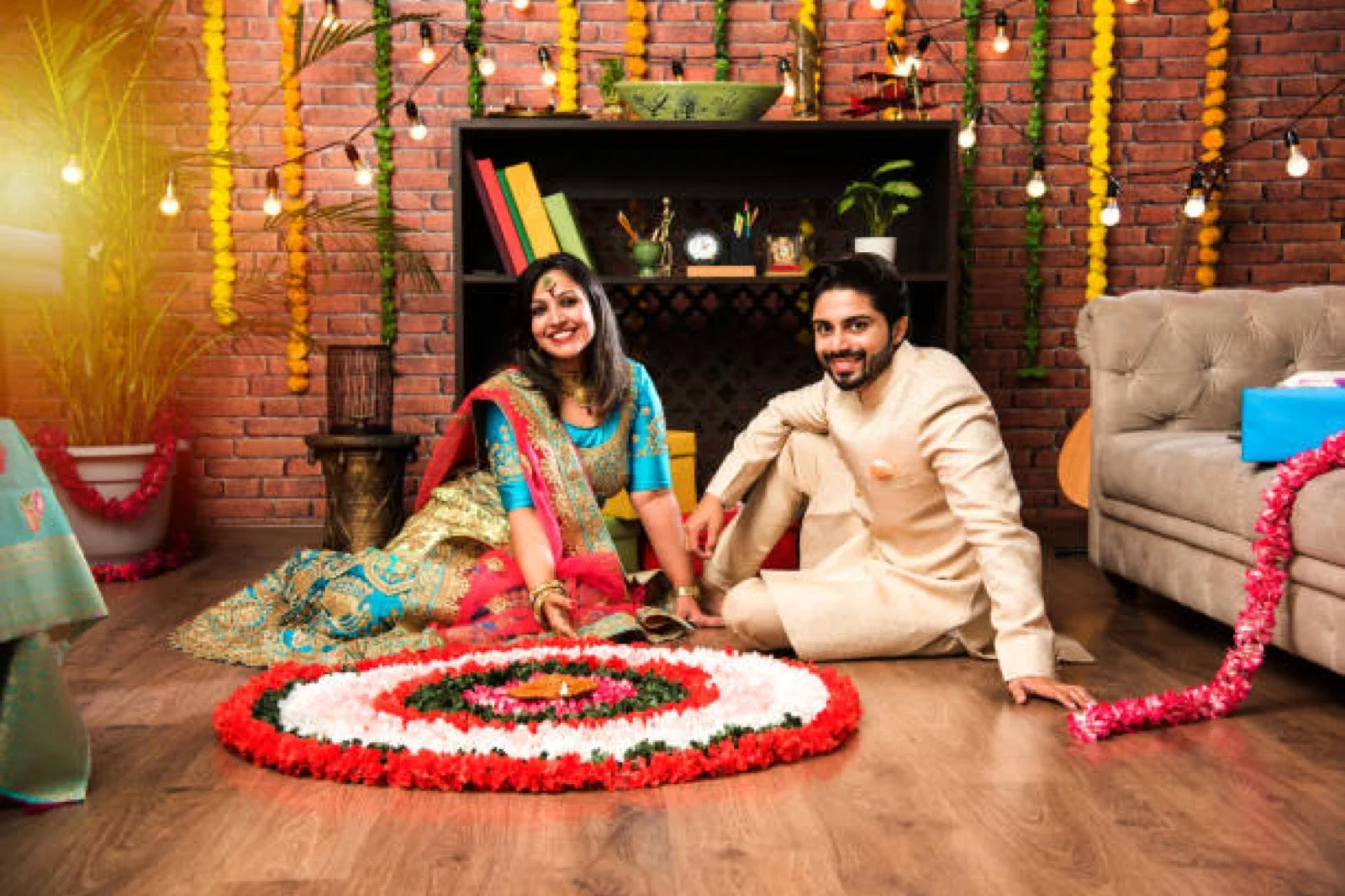 Young couple beside an Onam pookalam