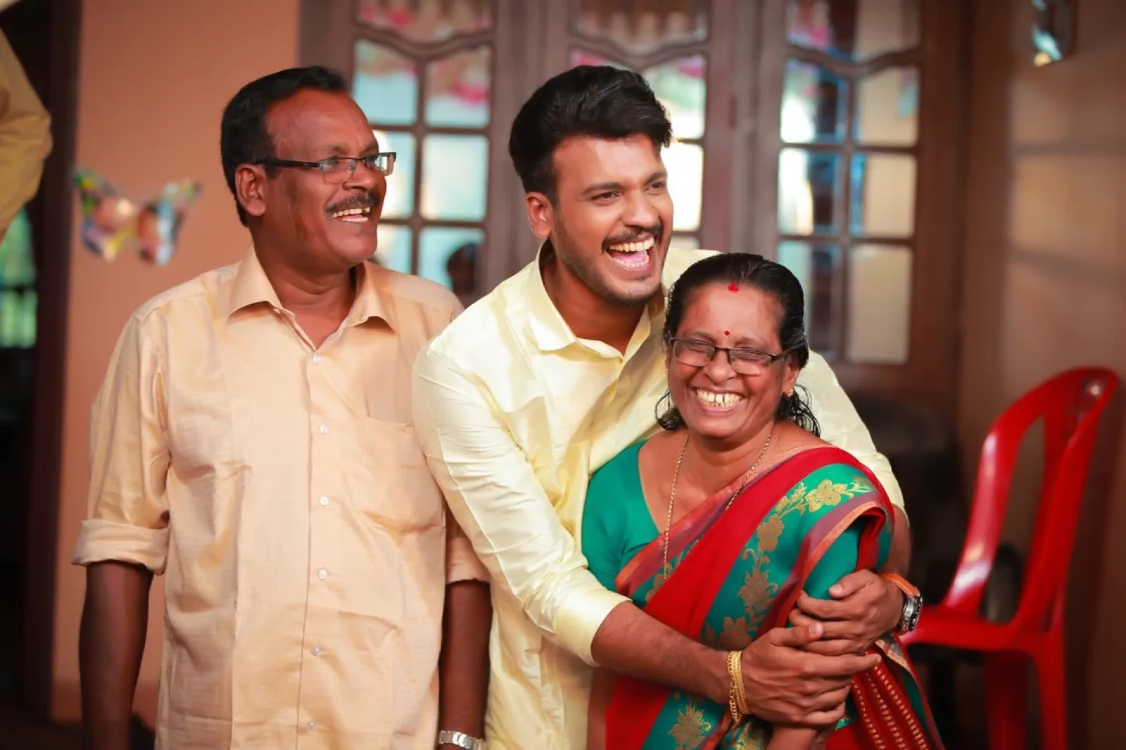 Son celebrating Onam with his parents